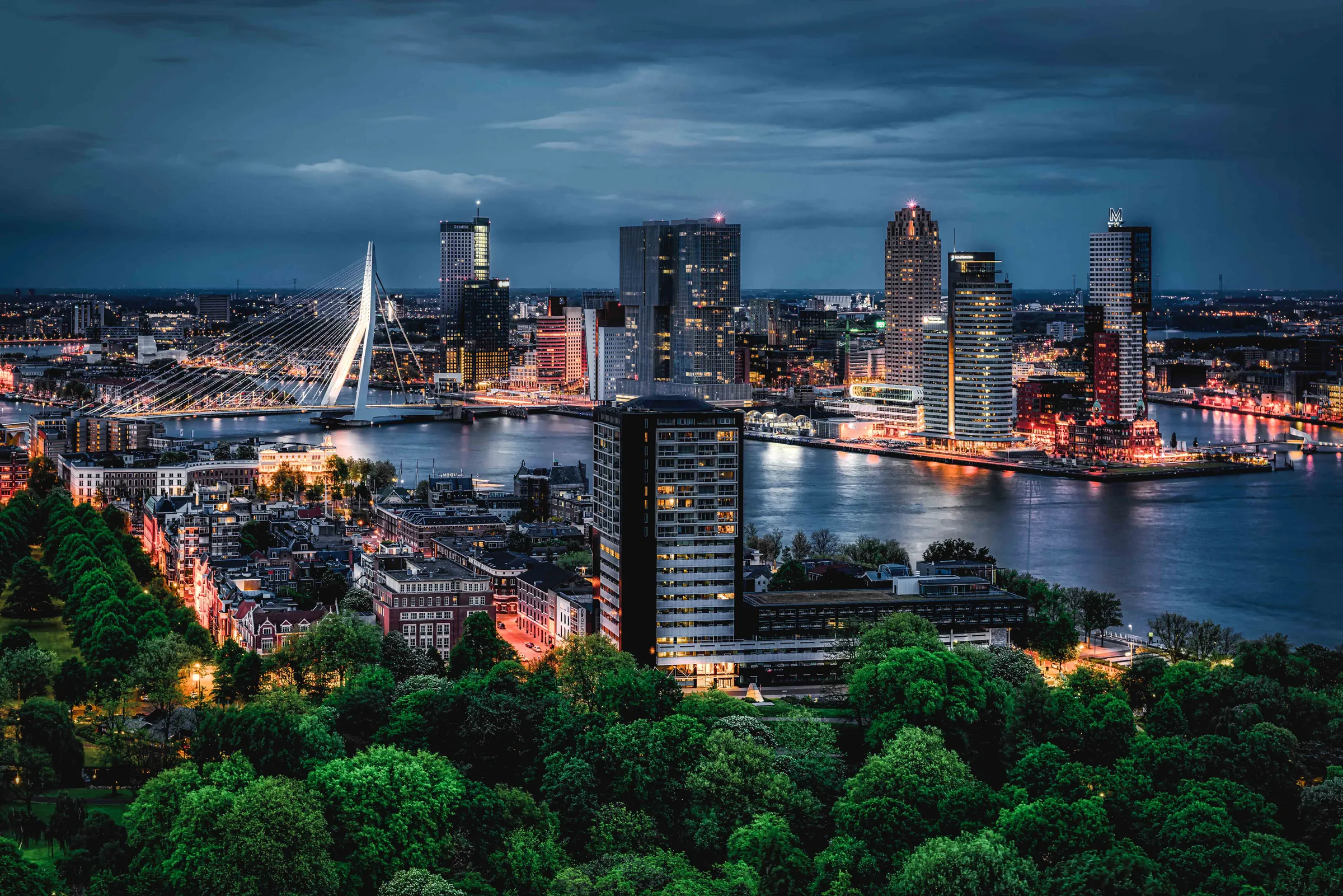 De Rotterdamse skyline en Erasmusbrug bij schemering, gefotografeerd door Timo Bongers